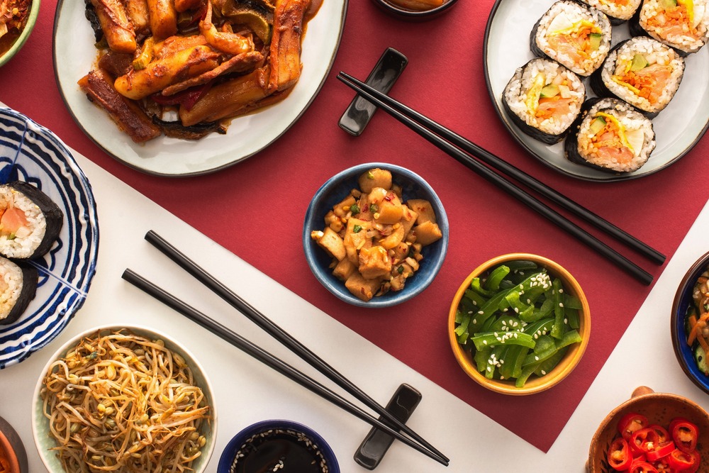 vista aerea de mesa con platos de comida asiatica y palillos